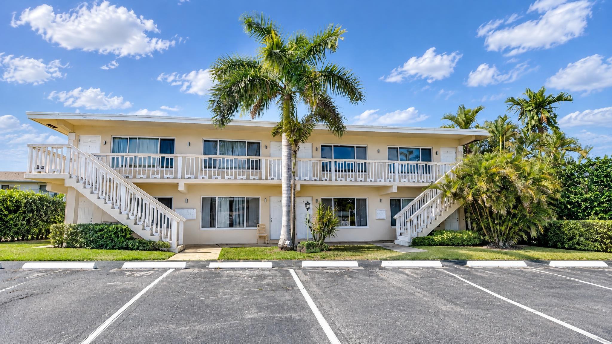 The same building after Picture It, straightened 16:9 shot with an empty lot, bright sky and vivid palms