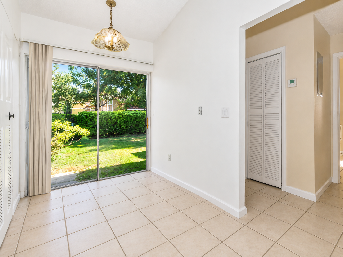 Clean, decluttered breakfast nook with a sliding door to the yard after editing in Picture It