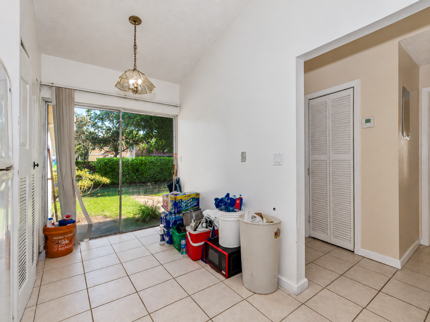 Breakfast nook cluttered with buckets, coolers, and boxes before editing